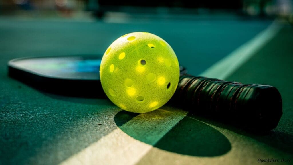 Close-up of a yellow pickleball resting on a paddle in sunlight, symbolizing clarity, awareness, and blind spots in business.