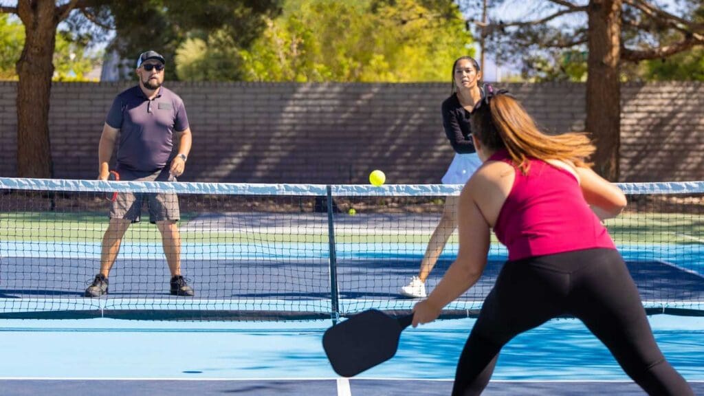 A group of pickleball players in action on the court, symbolizing hard work, teamwork, and learning through awareness in business.