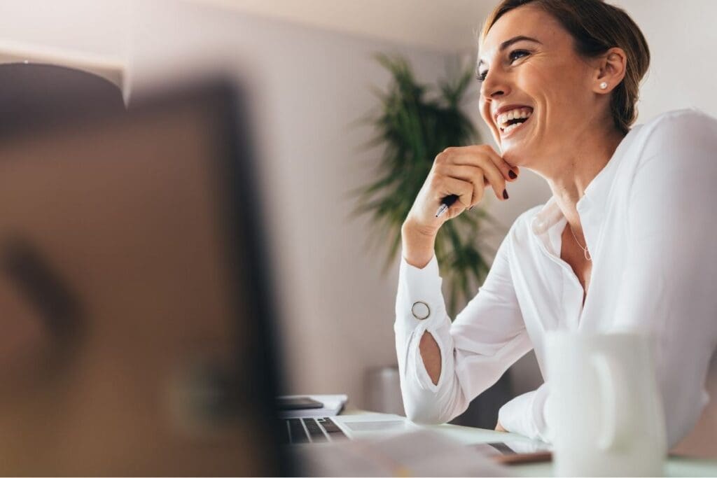 Female entrepreneur smiling peacefully after burnout recovery season while reflecting.